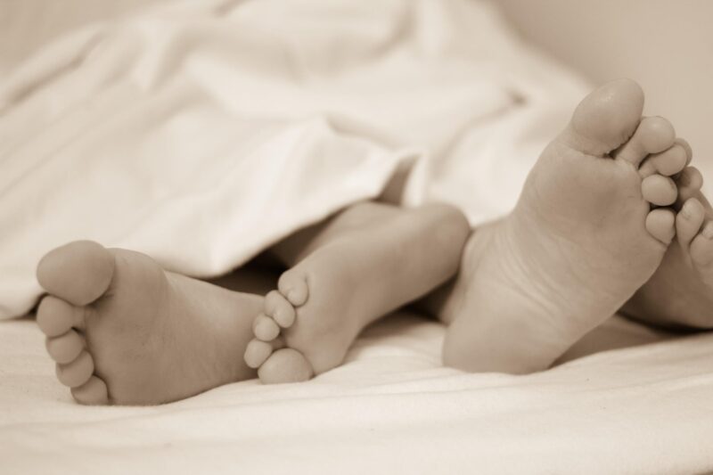 Sex first: man and woman's feet sticking out of a bed